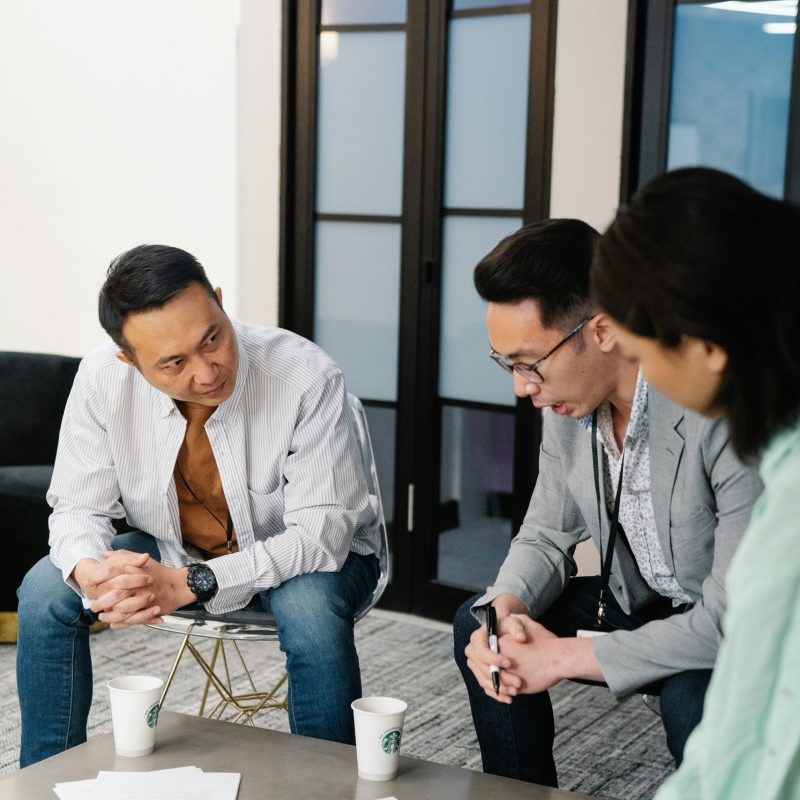 Three colleagues engage in a collaborative brainstorming session in a modern office.